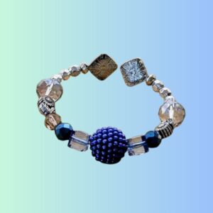 Pulsera Artesanal con Cuentas Cristalinas – Azul y Plateado Pulsera elástica hecha a mano con cuentas transparentes tipo cristal, detalles metálicos en plateado y un llamativo centro azul texturizado. Combina elegancia y estilo moderno, ideal para uso diario o como accesorio distintivo en ocasiones especiales. Ligera, cómoda y única. Perfecta para regalar o complementar cualquier outfit.